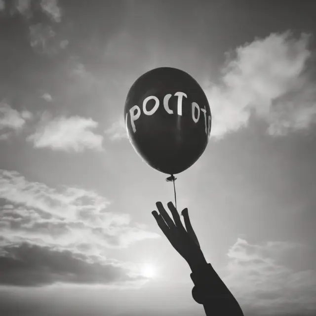 Man holding two hands releasing a balloon labeled