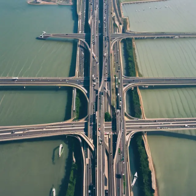 An elegant bridge spanning two continents with businesses and people crossing, representing an Export Trading Company connecting markets and enabling international transactions