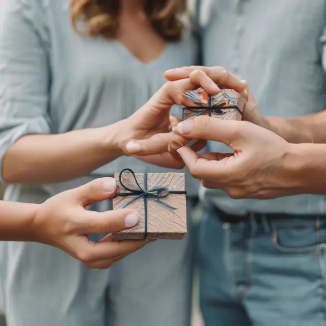Married couple sharing a gift box, each holding a smaller box symbolizing their individual $34,000 annual exclusion amount doubled through gift splitting.