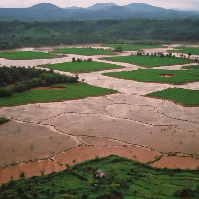 Image of Bauxite mountains and rice paddies in Guinea, representing the country