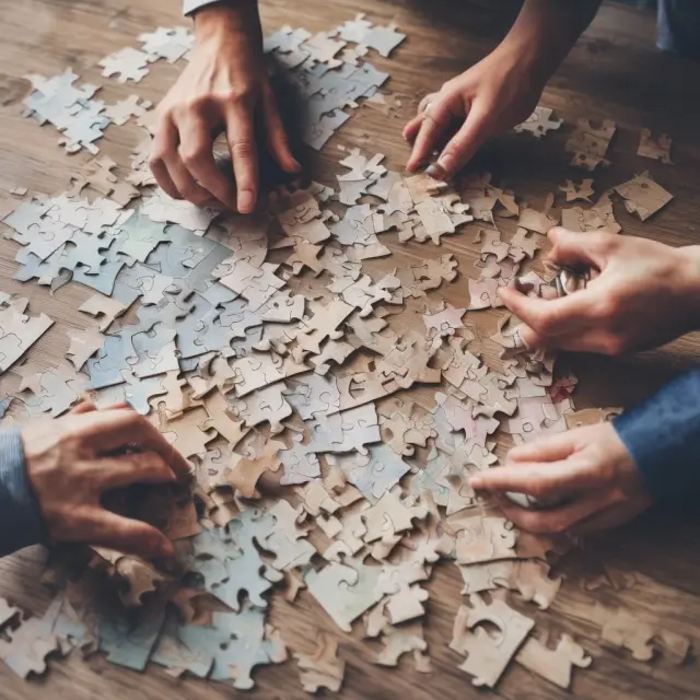 A landlord and tenant working together to assemble a jigsaw puzzle of a property, symbolizing their collaborative efforts in managing maintenance expenses.